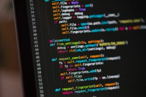 Black computer screen showing colourful lines of code.